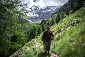 Gran Paradiso couple trekking in open field with mountains