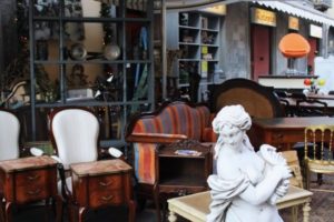 Antique furniture and statues displayed outside antique shop at Turin Balon market